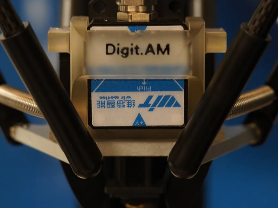 Gros plan du capteur inertiel dix axes monté sur l’effecteur de Digit.AM, entre les bras du delta.